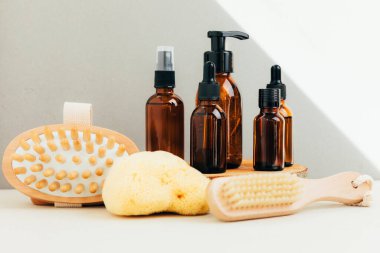 Doğal kozmetik seti. Kehribar şişeleri yüz maskesi, banyo sıvısı ahşap barın üzerinde beton bir arka plan. Ön görünüm