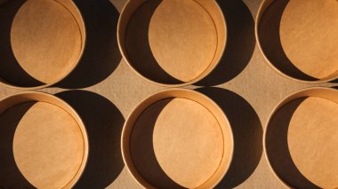 Kağıt kaplar, kahverengi arka planda tabaklar. Çevre dostu, sıfır atık konsepti. Web afişi. Üst görünüm