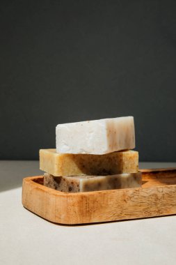 Doğal malzemelerden el yapımı sabun, çeşitli otlar. Sürdürülebilir kullanım kavramı, ahşap tepside banyo ürünleri. Ön görünüm