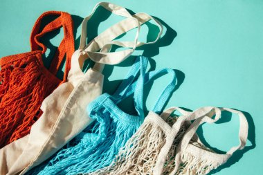 Mavi, turuncu ve bej ile yeniden kullanılabilir ağ torbaları güneşli bir günde mavi arka planda. Ağ alışveriş torbaları. Sürdürülebilir kullanım kavramı