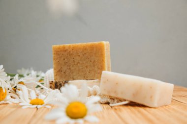 Doğal malzemelerden elde yapılan sabun, çeşitli otlar, papatya çayı. Sürdürülebilir kullanım kavramı, ahşap zeminde banyo ürünleri. Ön görünüm