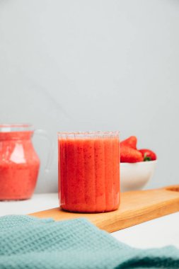 Şeffaf bardaklarda meyve suyu. Beton arka planda kırmızı çilekli smoothie. Sağlıklı beslenme kavramı. Ön görünüm