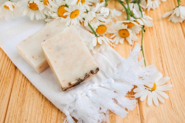 Doğal malzemelerden elde yapılan sabun, çeşitli otlar, papatya çayı. Sürdürülebilir kullanım kavramı, ahşap zeminde banyo ürünleri. Üst görünüm