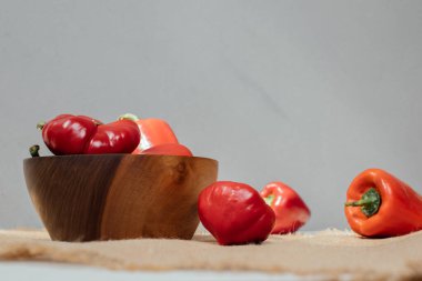 Beton arka planda farklı boyutlarda dolmalık biber. Bahçe geçmişi, domates ve dolmalık biber hasadı. Olgunlaşmış kırmızı domatesler. Ön görünüm