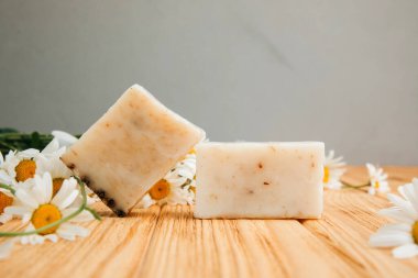 Doğal malzemelerden elde yapılan sabun, çeşitli otlar, papatya çayı. Sürdürülebilir kullanım kavramı, ahşap bir masada banyo ürünleri. Ön görünüm