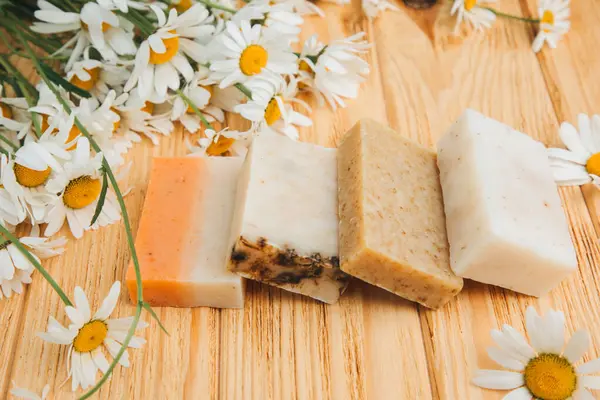 Doğal malzemelerden elde yapılan sabun, çeşitli otlar, papatya çayı. Sürdürülebilir kullanım kavramı, ahşap zeminde banyo ürünleri. Üst görünüm