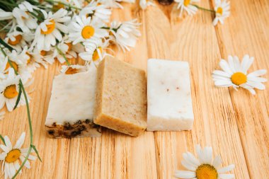 Doğal malzemelerden elde yapılan sabun, çeşitli otlar, papatya çayı. Sürdürülebilir kullanım kavramı, ahşap zeminde banyo ürünleri. Üst görünüm