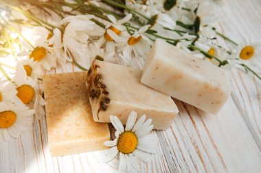 Doğal malzemelerden elde yapılan sabun, çeşitli otlar, papatya çayı. Sürdürülebilir kullanım kavramı, ahşap zeminde banyo ürünleri. Üst görünüm