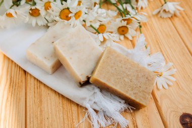 Doğal malzemelerden elde yapılan sabun, çeşitli otlar, papatya çayı. Sürdürülebilir kullanım kavramı, ahşap zeminde banyo ürünleri. Üst görünüm