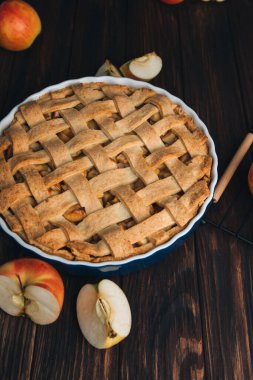 Elmalı turta koyu ahşap arka planda, beyaz mutfak havlusuyla mavi formda. Hazır turta. Üst görünüm