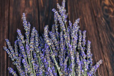 Gri ahşap arka planda bir buket taze lavanta. Çiçek açan arka plan. Tebrik kartı. Üst görünüm