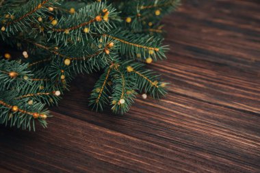 Yeni yıl, Noel geçmişi. Koyu ahşap arka planda yeşil bir Noel ağacının dalları. Üst görünüm