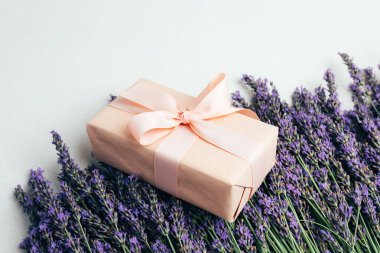 Selamlaşmak için arka plan. Yumuşak pembe kağıda sarılmış lavanta çiçekleri. Üst görünüm