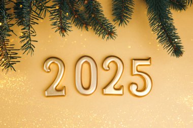 Noel 'i kutlamak, yeni yıl geçmişi. Altın rakamlar, 2025 numara, sarı arka planda çam dalları. Üst görünüm