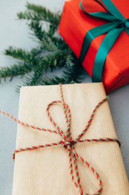 Noel, şenlikli bir geçmiş. Gri arka planda yeşil kurdeleli kırmızı ve kahverengi kağıtlara sarılı hediyeler. Üst görünüm