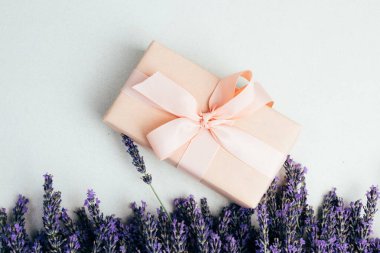 Selamlaşmak için arka plan. Yumuşak pembe kağıda sarılmış lavanta çiçekleri. Üst görünüm