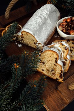 Siyah arka planda Noel ağacının yeşil dalları olan ahşap bir tahtada çalınmış Noel ağacı. Noel arkaplanı, Noel tatlısı