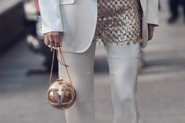 ミラノ イタリア 2022年2月25日 ストリートのぼやけた背景に丸い金色のボールバッグを運ぶ流行の衣装で匿名の女性をクロップ ロイヤリティフリーのストック画像