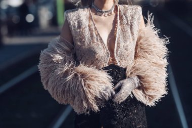 Milan, Italy - February 25, 2022: Female in stylish lace clothes with fur sleeves in Milan.