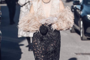 Milan, Italy - February 25, 2022: Female in stylish lace clothes with fur sleeves in Milan.