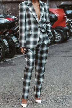Milan, Italy - February 25, 2022: Crop female in stylish checkered suit in Milan, Italy.
