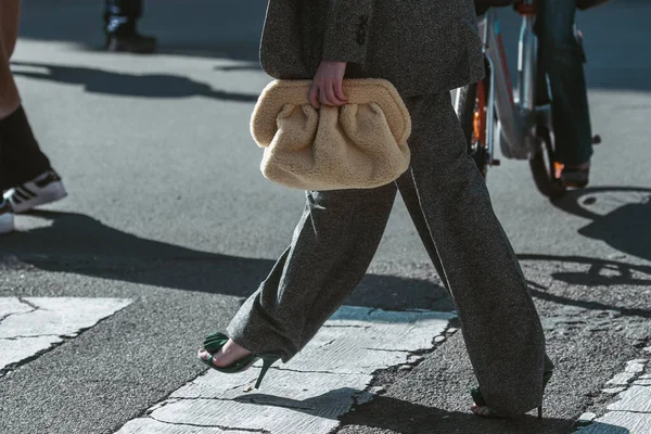 Milan, Italy - February 25, 2022: Female in stylish gray suit with yellow lime top with bag in Milan, Italy.