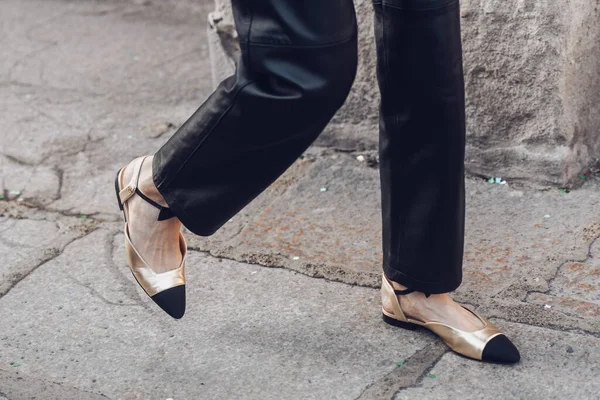 stock image Milan, Italy - February 24, 2022: of Woman wearing black trousers and golden pointy toe shoes.