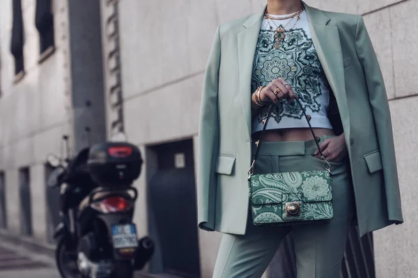 Milan, Italy - February 25, 2022: Female wearing a light green blazer, ornamental shirt and matching ornamental handbag.