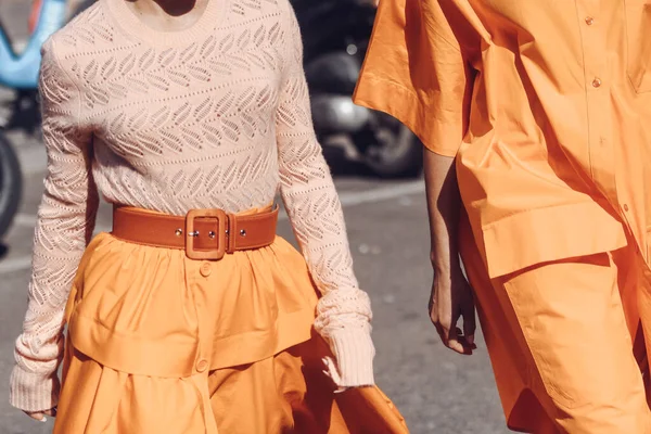ミラノ イタリア 2022年2月25日 ミラノ ファッションウィーク中の晴れた日に歩くオレンジの衣装で匿名の女性と男性をトリミング ストックフォト