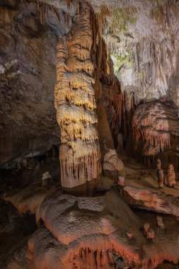 Postojna mağarasında yoğun renklerde sarkıtlarla dolu bir sütun