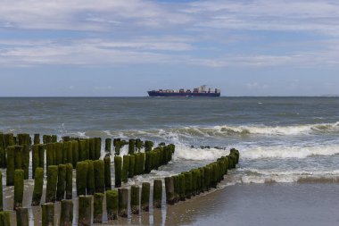 Gemi trafiği Scheldt 'in ağzından Kuzey Denizi' ne doğru sisli bir mesafede Vlissingen 'in hatlarıyla ilerliyor.