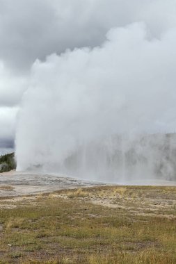 Yellowstone Ulusal Parkı 'ndaki patlama sırasında Old Faithful' un üstünde büyük buhar bulutları ve sis vardı.
