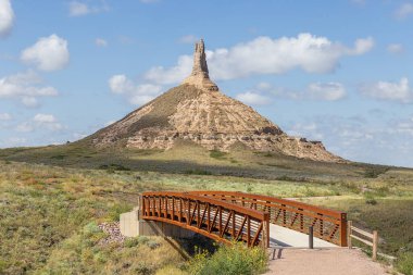 The bridge leading to Chimney Rock, a geological rock formation in the North Platte River valley clipart