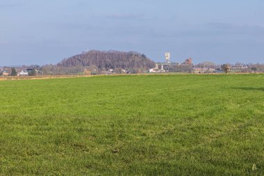 Blegny madeninin çevresindeki kömür yığını ve tarımsal faaliyetlerle uzak bir görüntüsü var.