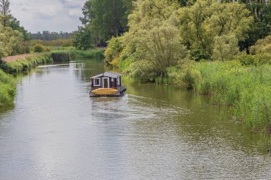 Biesbosch Ulusal Parkı 'ndaki küçük bir kanalda yüzen yüzen yüzen ev.