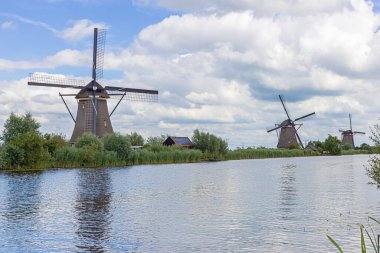 1740 yılından kalma üç yel değirmeni Kinderdijk çevresindeki alçak arazileri sele karşı korumak için bir kanal boyunca art arda dizilmiş.
