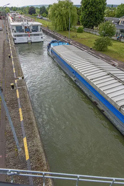 Editör: AMFREVILLE-SOUS-LES-MONTS, EURE, FRANCE, 8 Mayıs 2025 - Büyük nehir yolcu gemisi ve Amfreville-sous-les-Monts 'un kilitlerine tıkıştırılmış bir mavna,