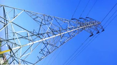 Çelik elektrik direği ve yüksek gerilim hattı mavi gökyüzü ile elektrik iletim videosu.