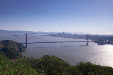 Geniş panoramik bir fotoğraf ikonik Golden Gate Köprüsü 'nün tüm uzunluğunu gösteriyor. Görüntü, bu dönüm noktasının büyüklüğünü ve ölçeğini mükemmel bir şekilde yansıtıyor.