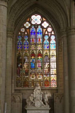 Bu çarpıcı dikey görüntü Gotik görkeminin gerçek bir temsilcisi olan Ghent Katedrali 'nin büyüleyici vitray işçiliğini yansıtıyor. Uzun pencere penceresi bir dizi hikayeyle dolu.