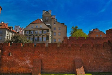 Varşova Eski Kasabası 'ndaki tarihi tuğla duvarların çarpıcı manzarası ve arka planda geleneksel Avrupa binaları. İyi korunmuş savunma duvarları Varşova zengin tarihinin bir parçasıdır.