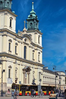 A vibrant photograph of St. Anne Church in Warsaw, Poland, showcasing its elegant Baroque architecture under a clear blue sky. The bright facade and intricate details make this historic landmark a clipart