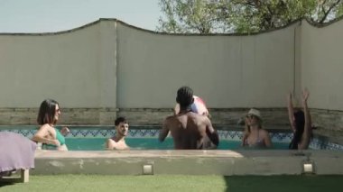 6 arkadaşının yüzme havuzunda top oynarken 4K videosu. Yüksek kalite 4k görüntü