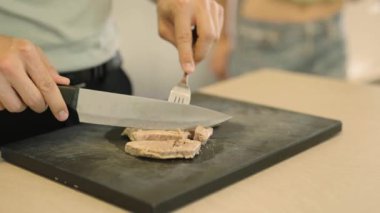 Tahtada pişmiş ton balığı kesen bir adamın 4K videosu. Yüksek kalite 4k görüntü