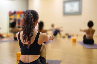 Genç Asyalı kız başkalarıyla yoga yapıyor. Yoga