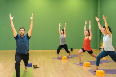 Yoga öğretmeni bir grup öğrenciye Ashta Chandrasana pozunu öğretiyor. Yoga.