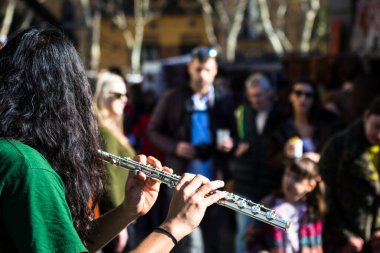 Musician on the street playing flute in front of passers-by. Madrid, Spain, 24 January 2016.