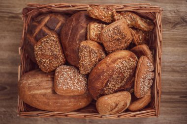 Ahşap bir masada sepetin içinde çeşitli hamur işleriyle kompozisyon.