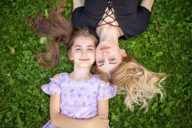 Anne ve kızı çimlere sarılıyor..