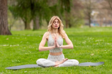 Lotustaki kadın parkta meditasyon yapıyor..